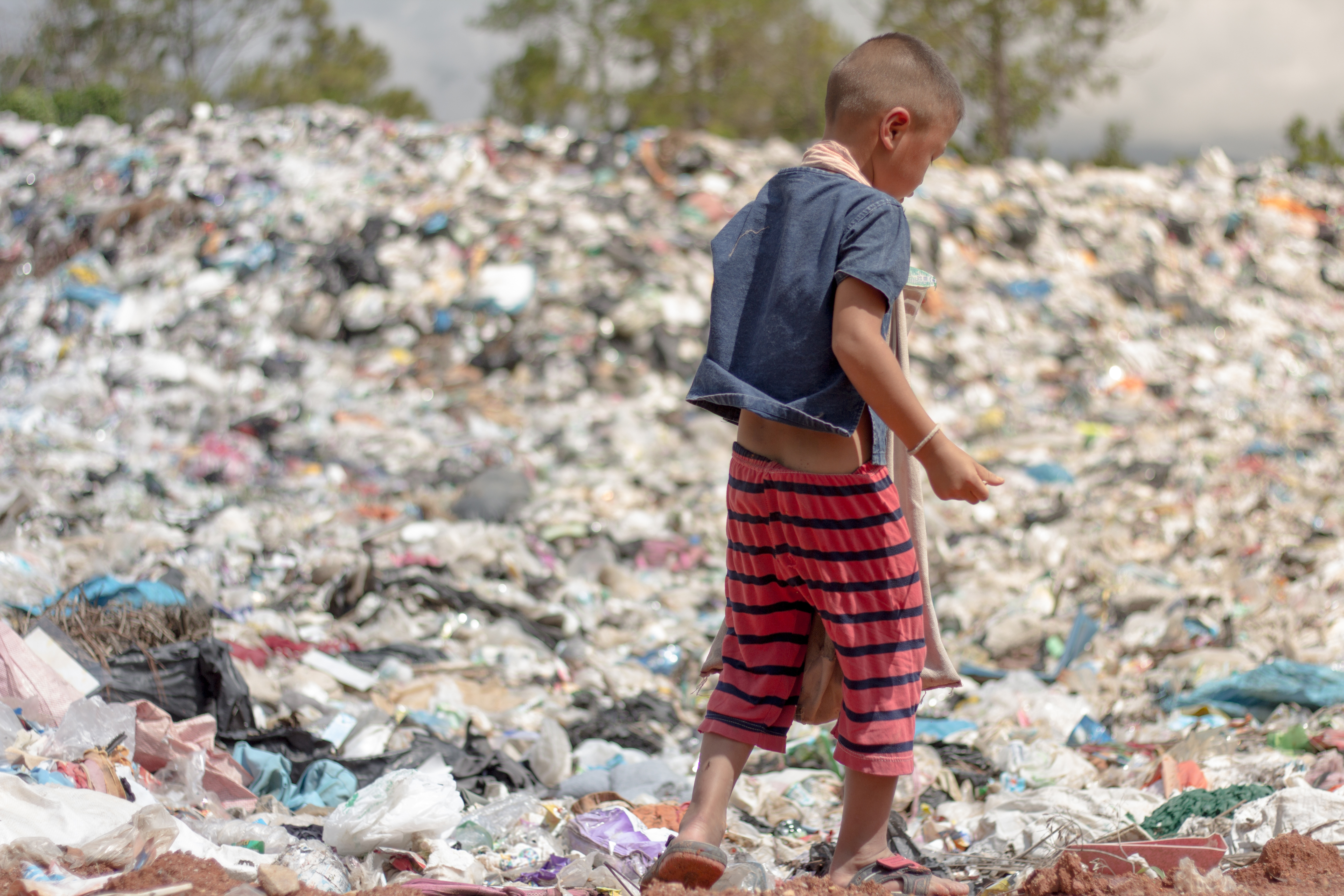 Child walking through landfill